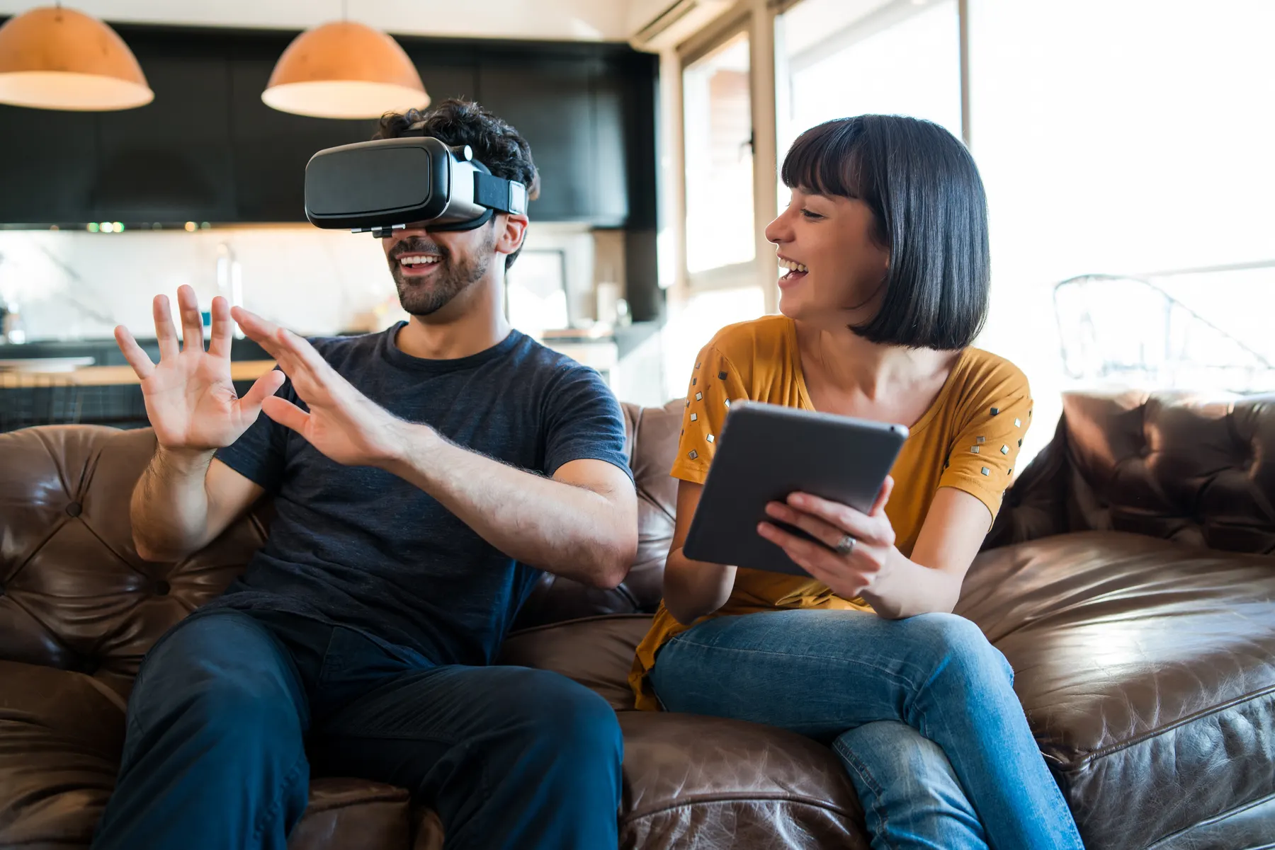 Pareja jugando videojuegos con lentes de realidad virtual en casa