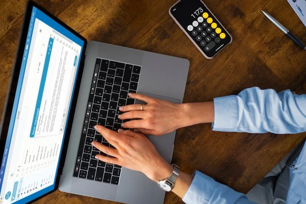 Una persona revisa una laptop y una calculadora desde su escritorio